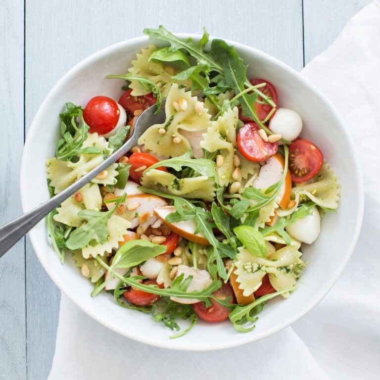 Diep bord gevuld met Pastasalade met pesto en kip